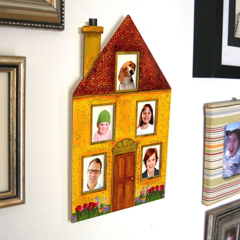 מסגרת מקרטון בצורת בית ובה 5 תמונות משפחה תלויה על קיר