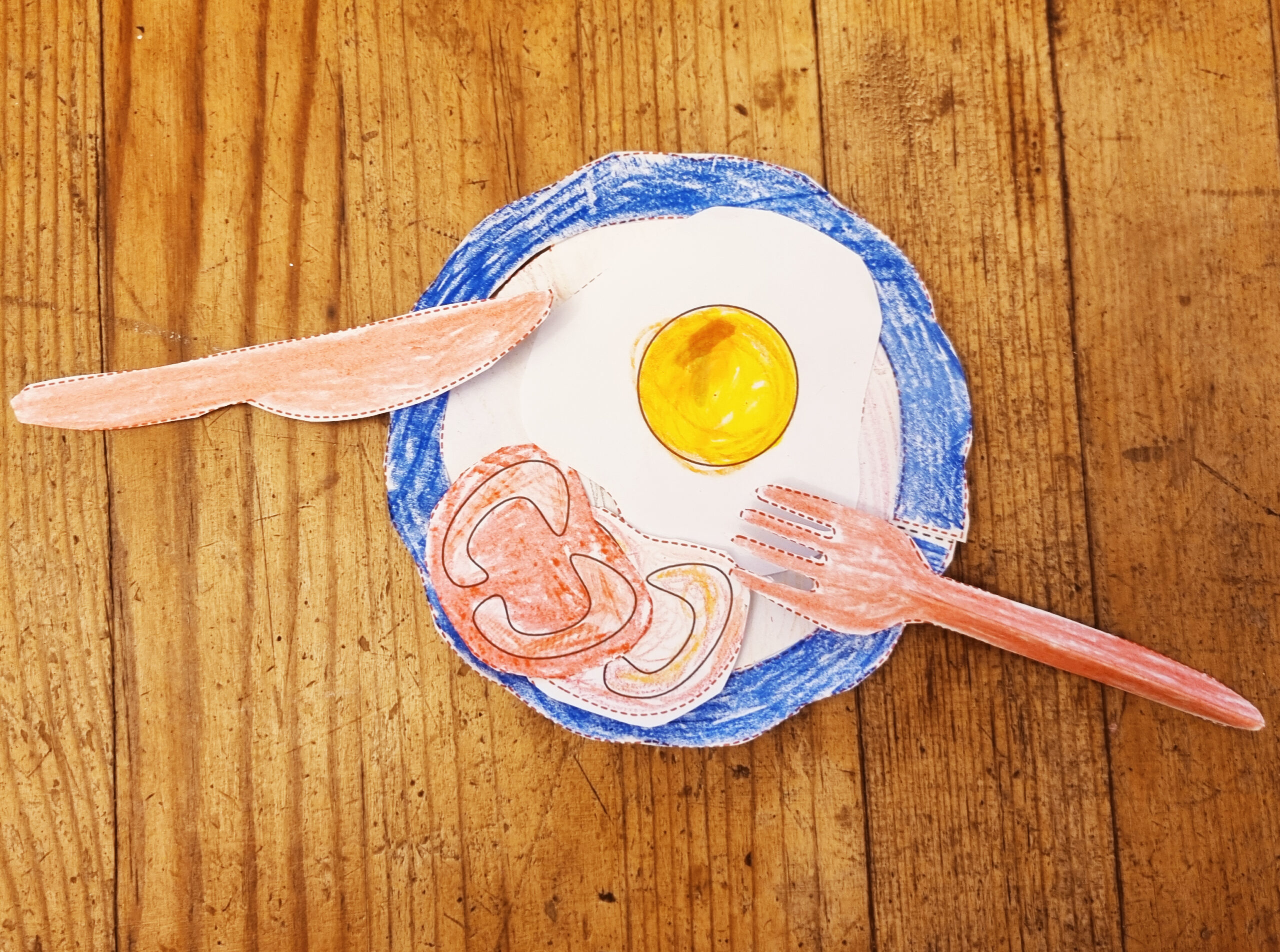 a colored paper plate with paper tomatoes and an egg