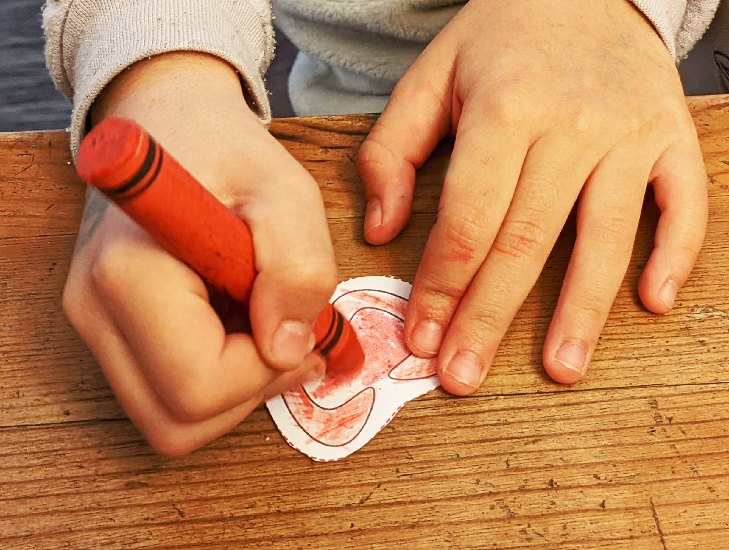 a kid coloring a paper tomato from the kitchen kit preschool worksheets